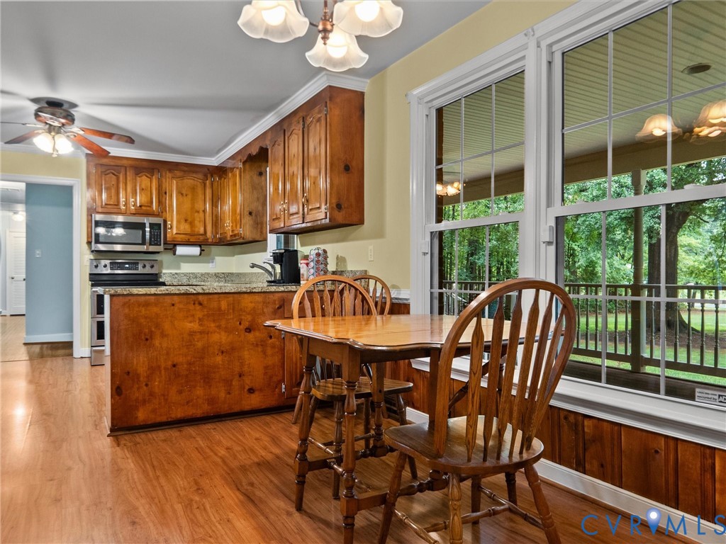 3420 State Rte 656 Powhatan, VA 23139 - Photo 13 of 37 a kitchen with stainless steel appliances granite countertop a stove a refrigerator a sink a dining table and chairs with wooden floor