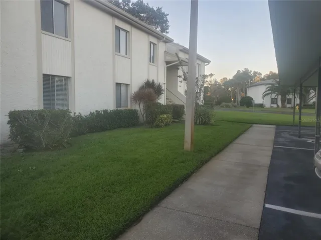 a view of a white house next to a yard and road