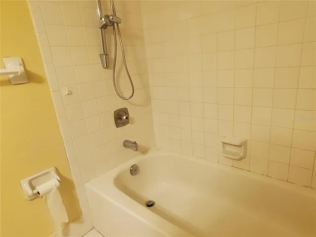 a bathroom with a bath tub with a shower