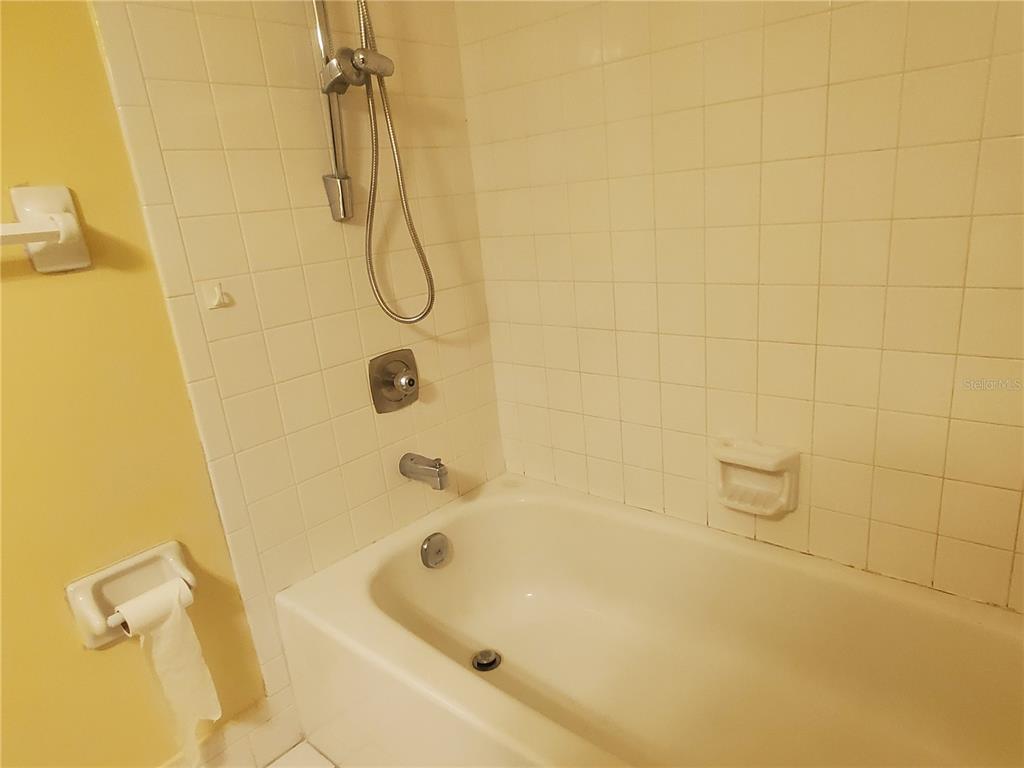 107 Cypress Court, Unit 2C Oldsmar, FL 34677 - Photo 8 of 12 a bathroom with a bath tub with a shower
