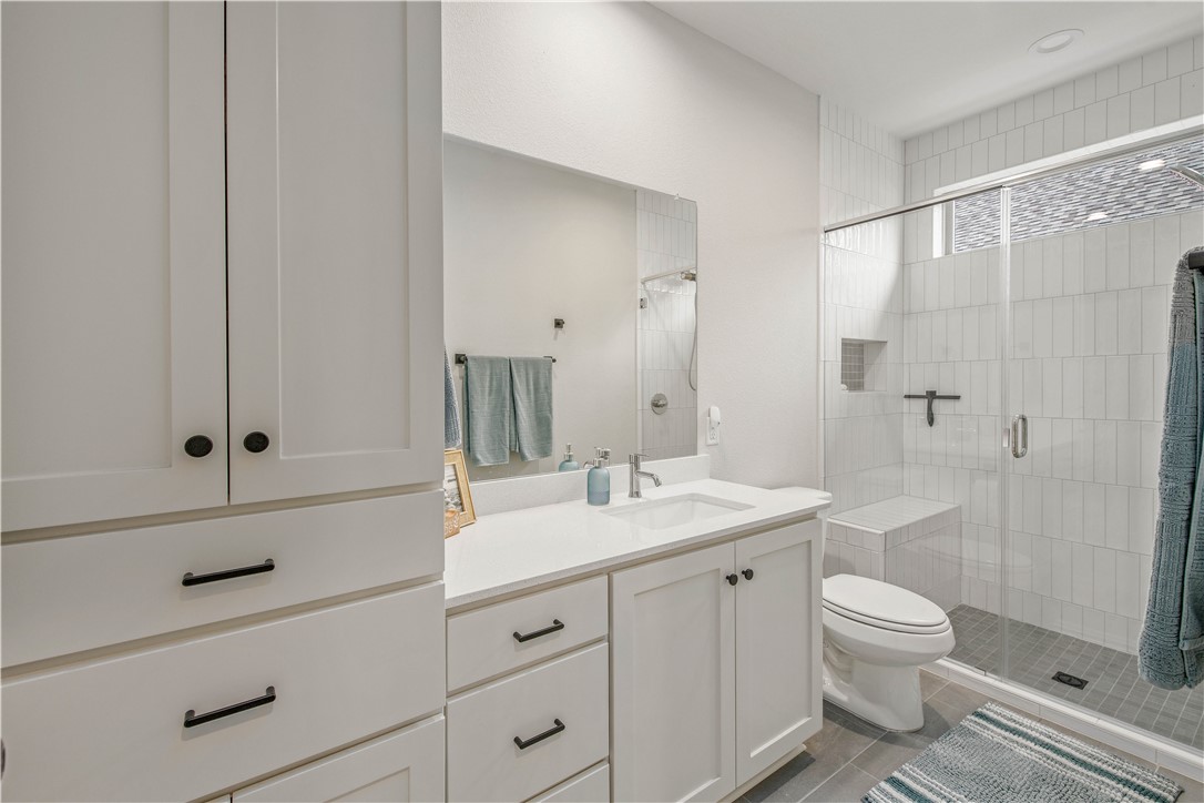 4309 Batona Court Bryan, TX 77802 - Photo 20 of 27 a bathroom with a shower sink vanity mirror and toilet
