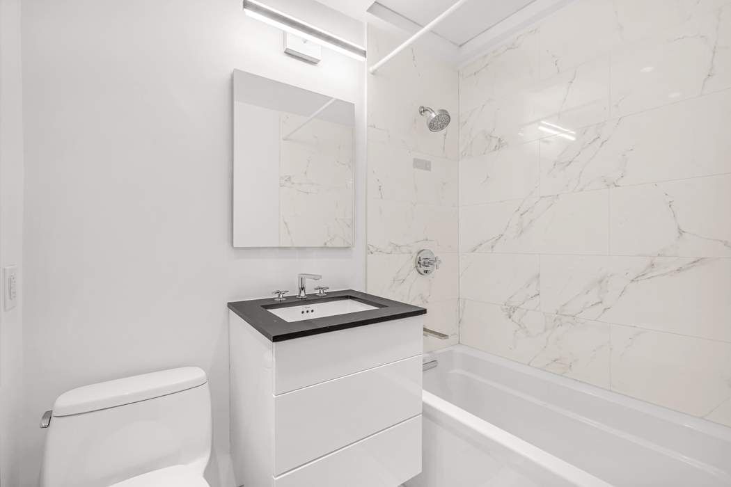 23 Waverly Place, Unit 3B Manhattan, NY 10003 - Photo 6 of 7 a bathroom with a granite countertop sink a toilet and shower