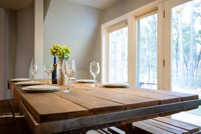 a kitchen with kitchen island a sink a stove a refrigerator cabinets and a dining table