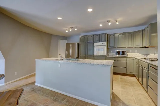 a kitchen with sink a microwave and wooden cabinets