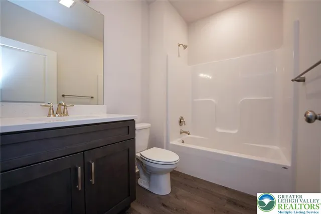 a bathroom with a sink a toilet a mirror and shower