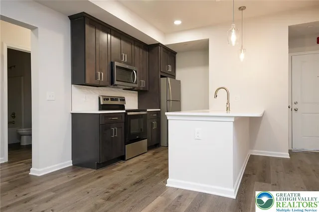 a kitchen with a sink a microwave a refrigerator and cabinets