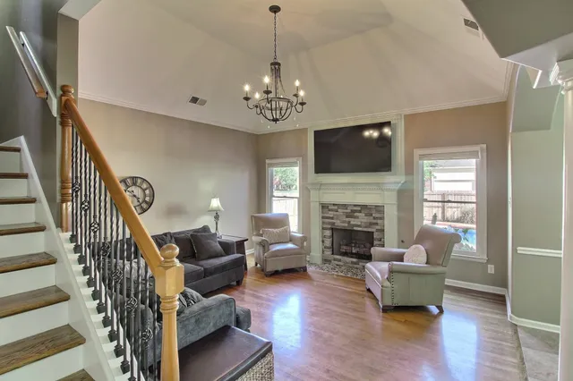 a living room with furniture a fireplace and a flat screen tv