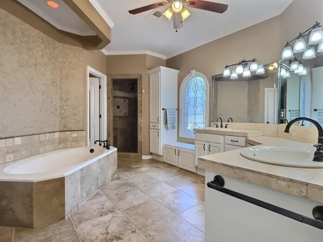 a spacious bathroom with a tub sink and a mirror