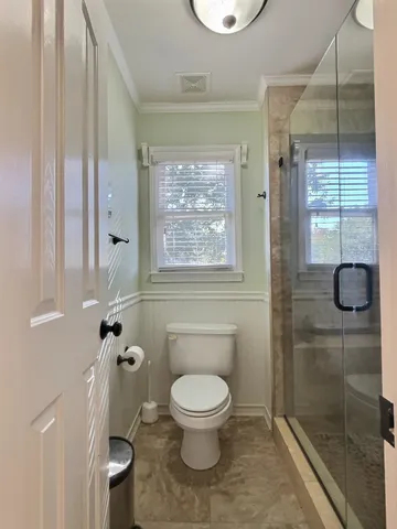 a bathroom with a toilet and a shower