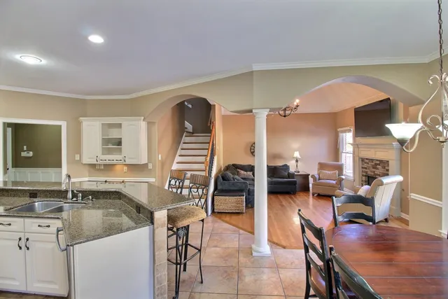a living room with furniture a piano and a large window