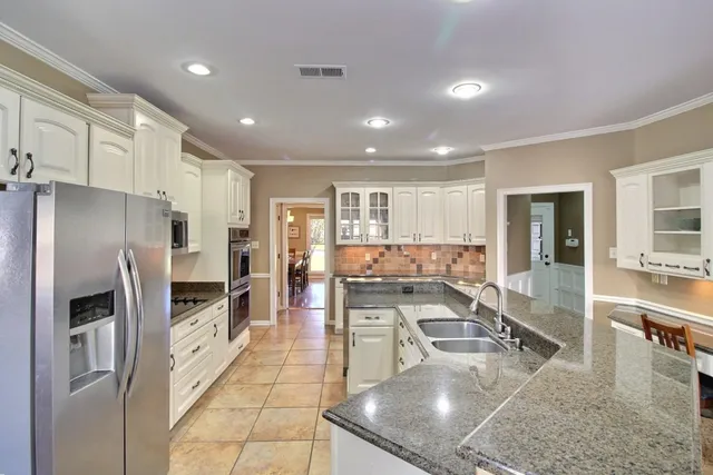 a kitchen with stainless steel appliances granite countertop a refrigerator and a sink