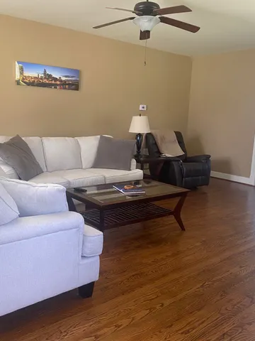 a dining hall with stainless steel appliances granite countertop a table chairs sink and window