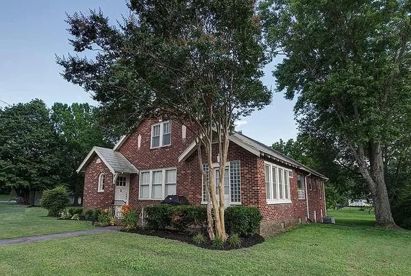 a front view of house with yard and green space