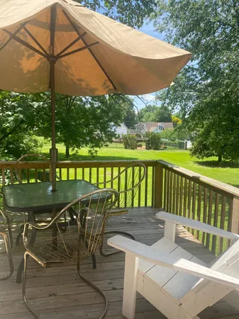 a view of a patio with table and chairs under an umbrella