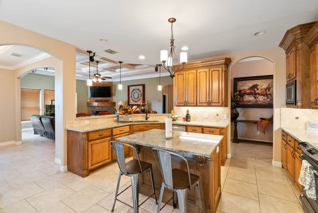 a kitchen with stainless steel appliances kitchen island granite countertop a sink and cabinets
