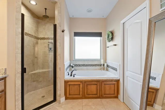a bathroom with a tub sink shower and mirror