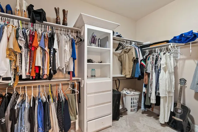 a view of walk in closet with clothes and shoes
