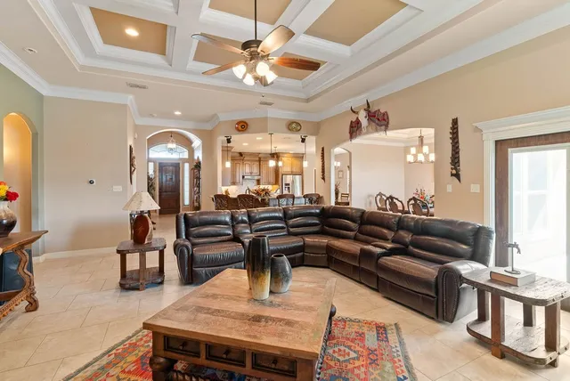 a living room with furniture kitchen view and a large window