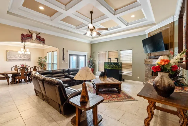a living room with furniture a flat screen tv and a chandelier
