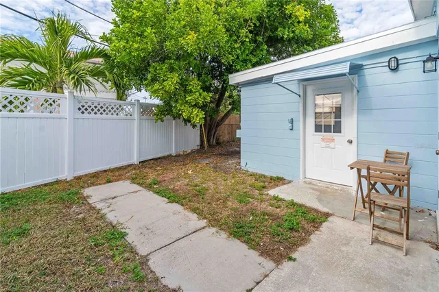 a backyard of a house with table and chairs