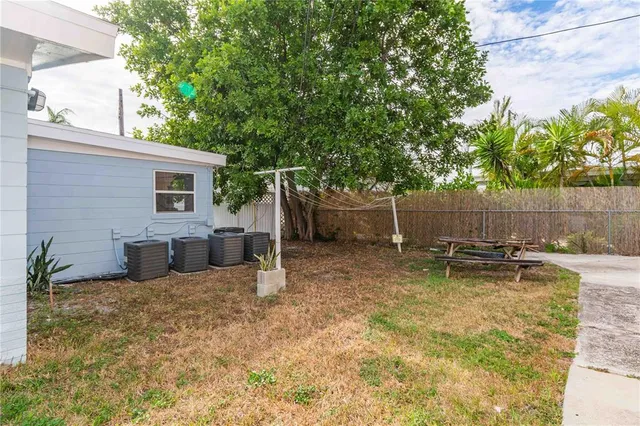 a view of a backyard with table and chairs and wooden fence