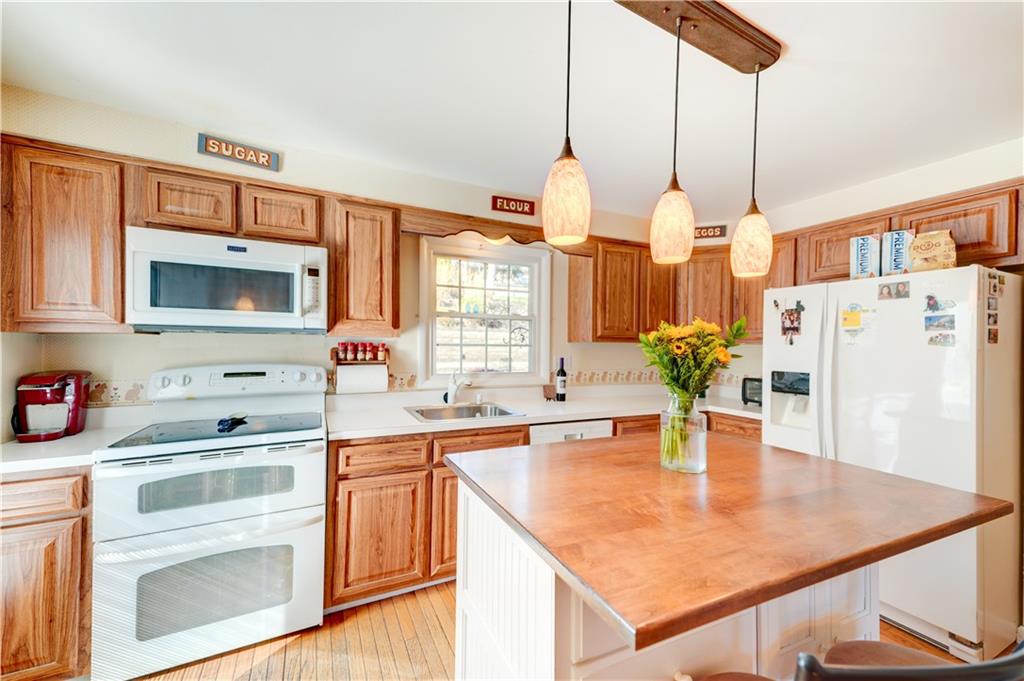 146 Morrison Drive Pittsburgh, PA 15216 - Photo 7 of 25 a kitchen with a stove a sink a dining table and chairs