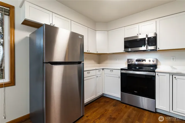 a kitchen with stainless steel appliances granite countertop a refrigerator stove a sink and a microwave