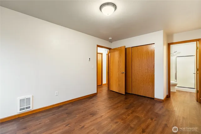 an empty room with wooden floor and closet