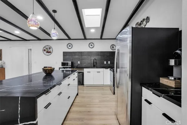 a kitchen with stainless steel appliances a sink stove and refrigerator