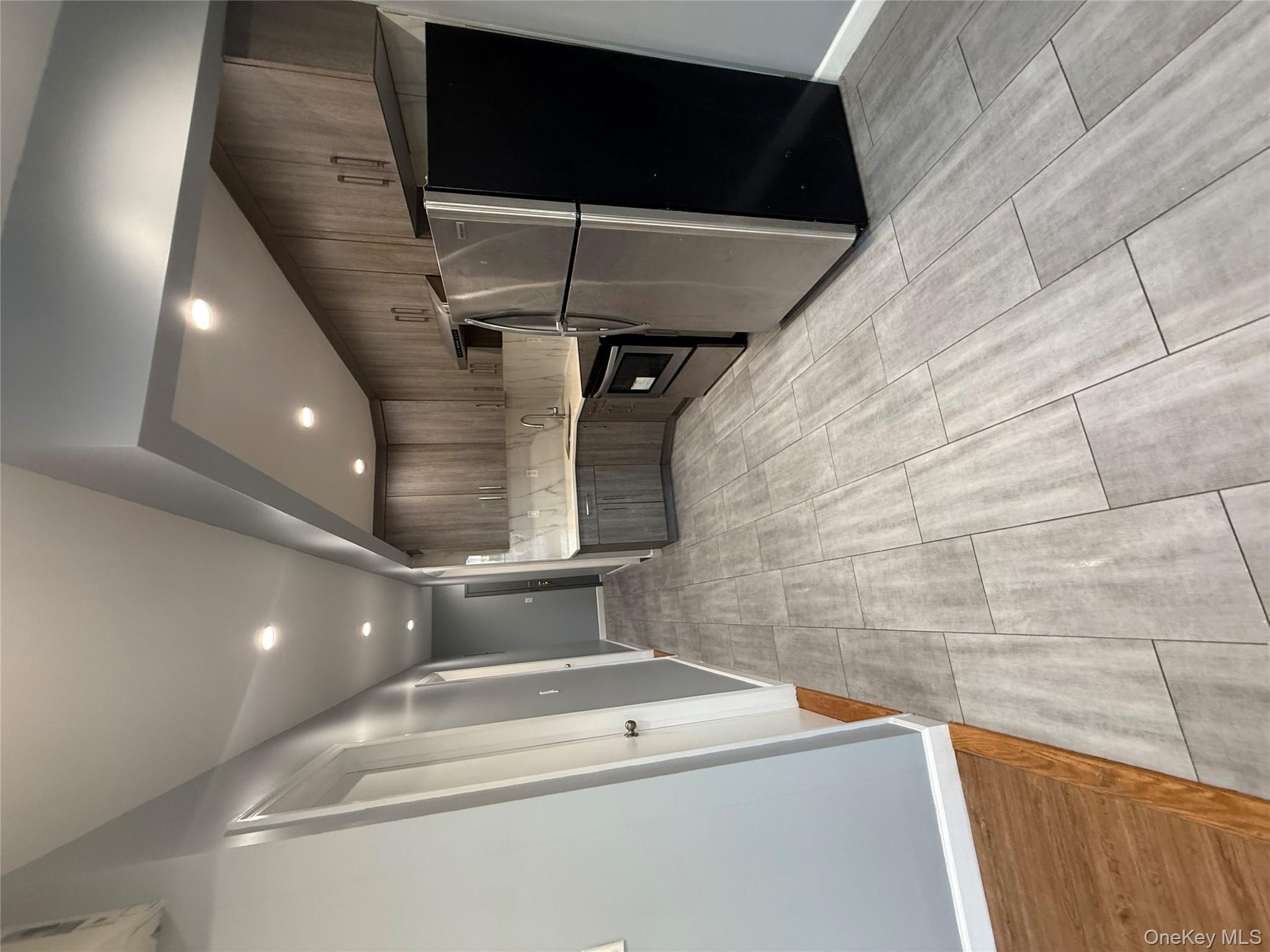 a view of kitchen with stainless steel appliances a refrigerator and a microwave