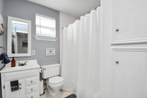 a bathroom with a sink a toilet and shower curtain