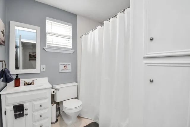 a bathroom with a sink a toilet and shower curtain