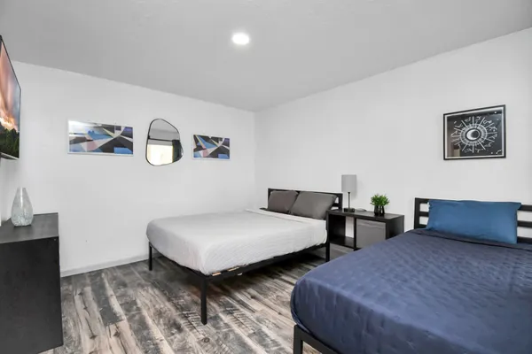 a bedroom with two beds and painting on the wall