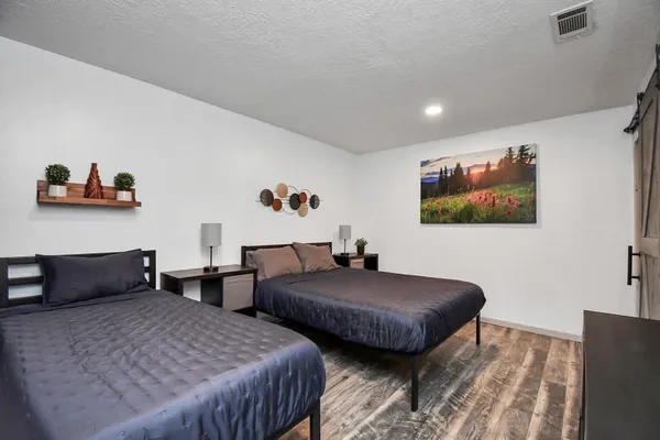 a bedroom with two beds and a desk