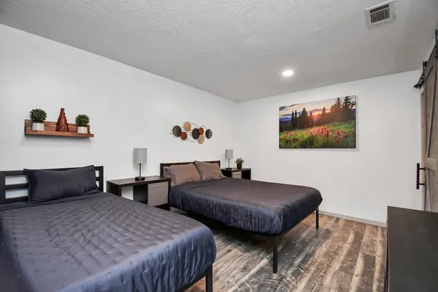 a bedroom with two beds and a desk