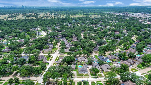 an aerial view of residential houses with outdoor space and trees