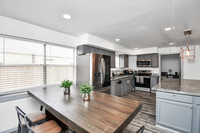 a kitchen with refrigerator a stove and chairs