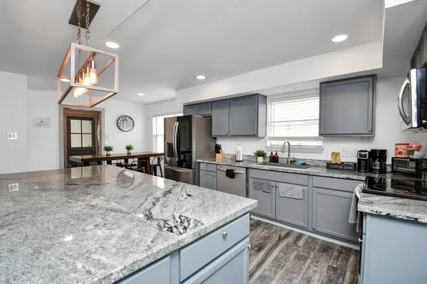 a kitchen with stainless steel appliances granite countertop a sink stove and refrigerator