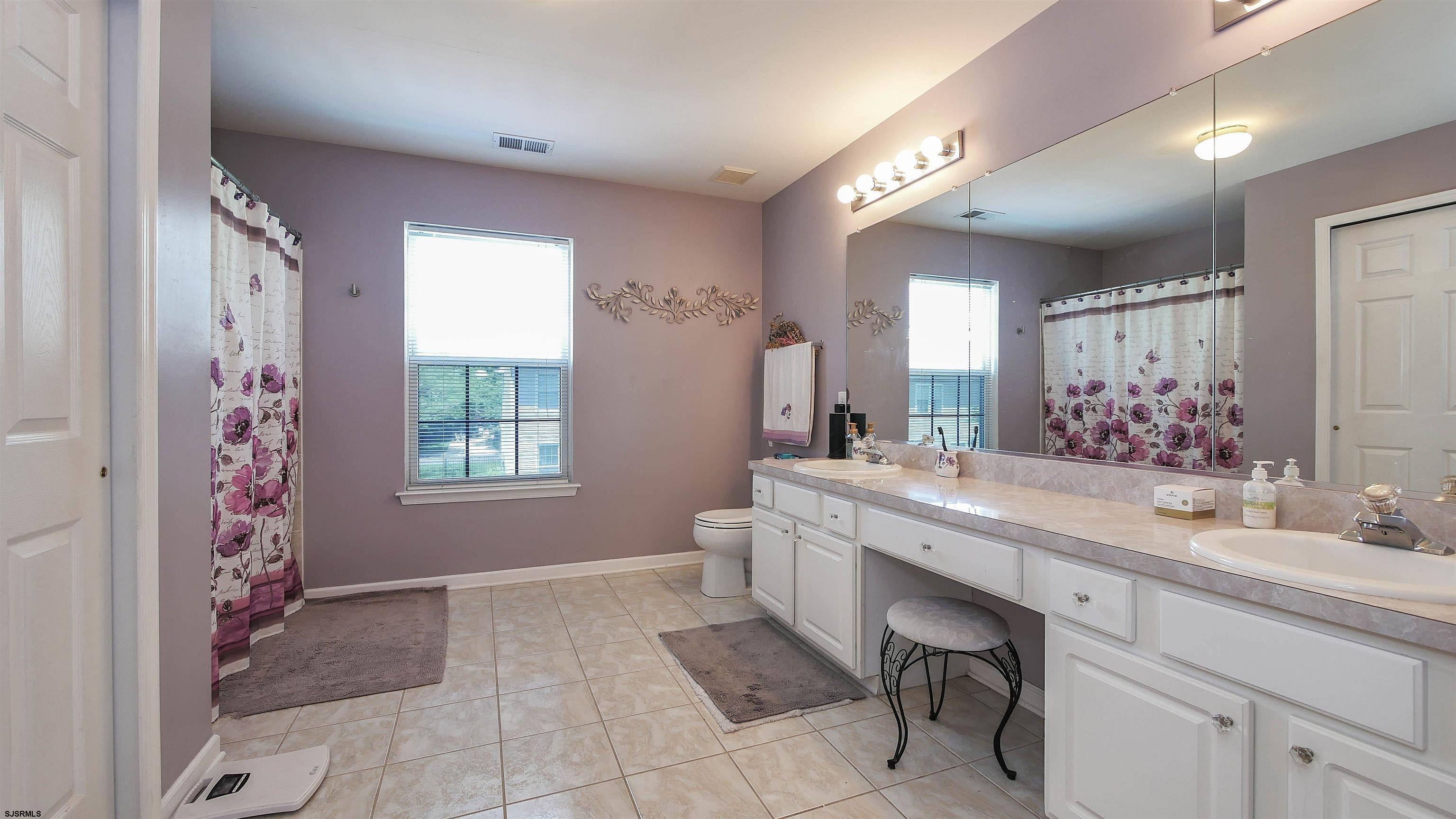 101 Haviv Drive Northfield, NJ 08225 - Photo 24 of 38 a spacious bathroom with a granite countertop sink a toilet a mirror and a tub