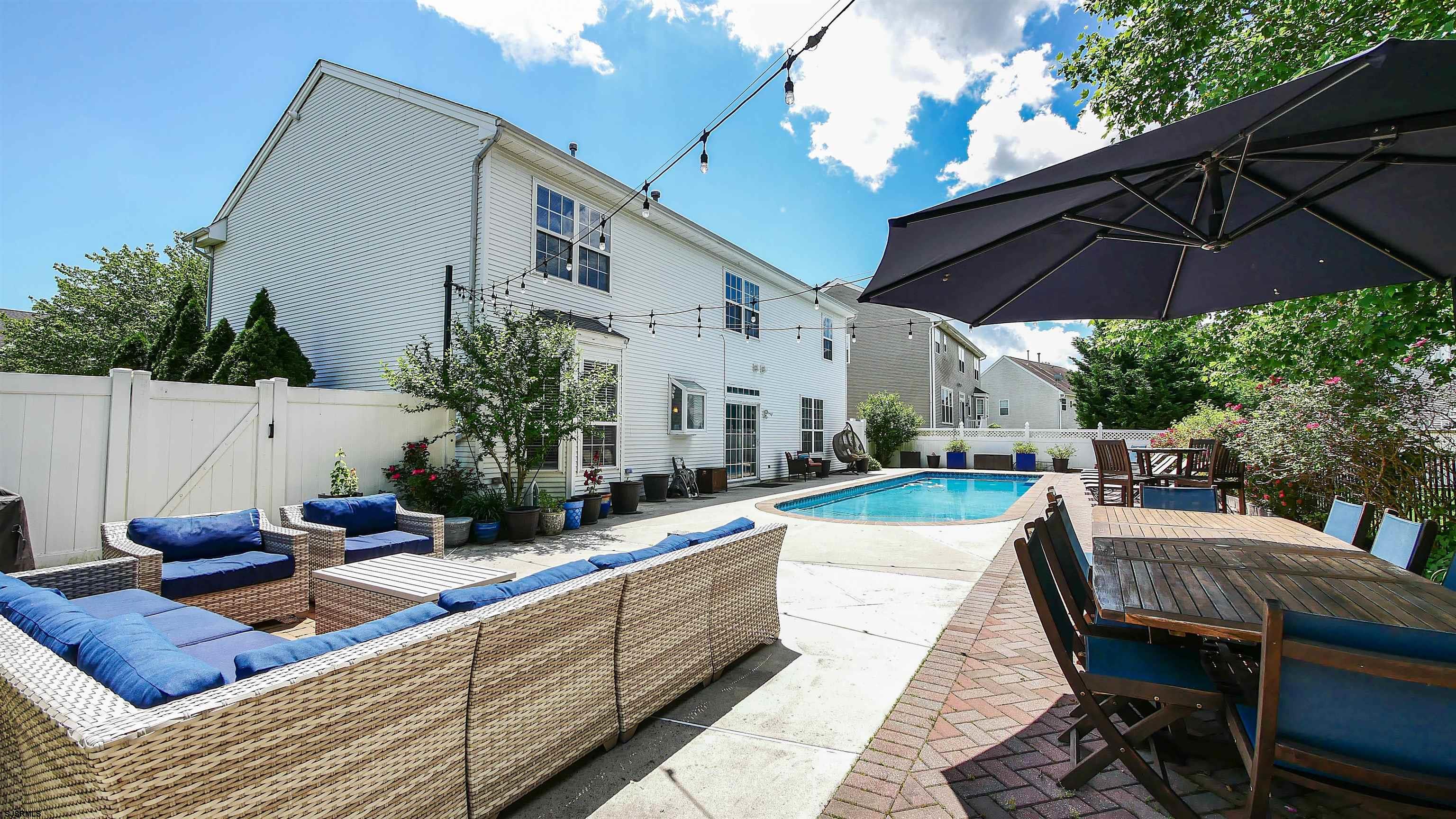 101 Haviv Drive Northfield, NJ 08225 - Photo 34 of 38 a view of a patio with couches table and chairs under an umbrella
