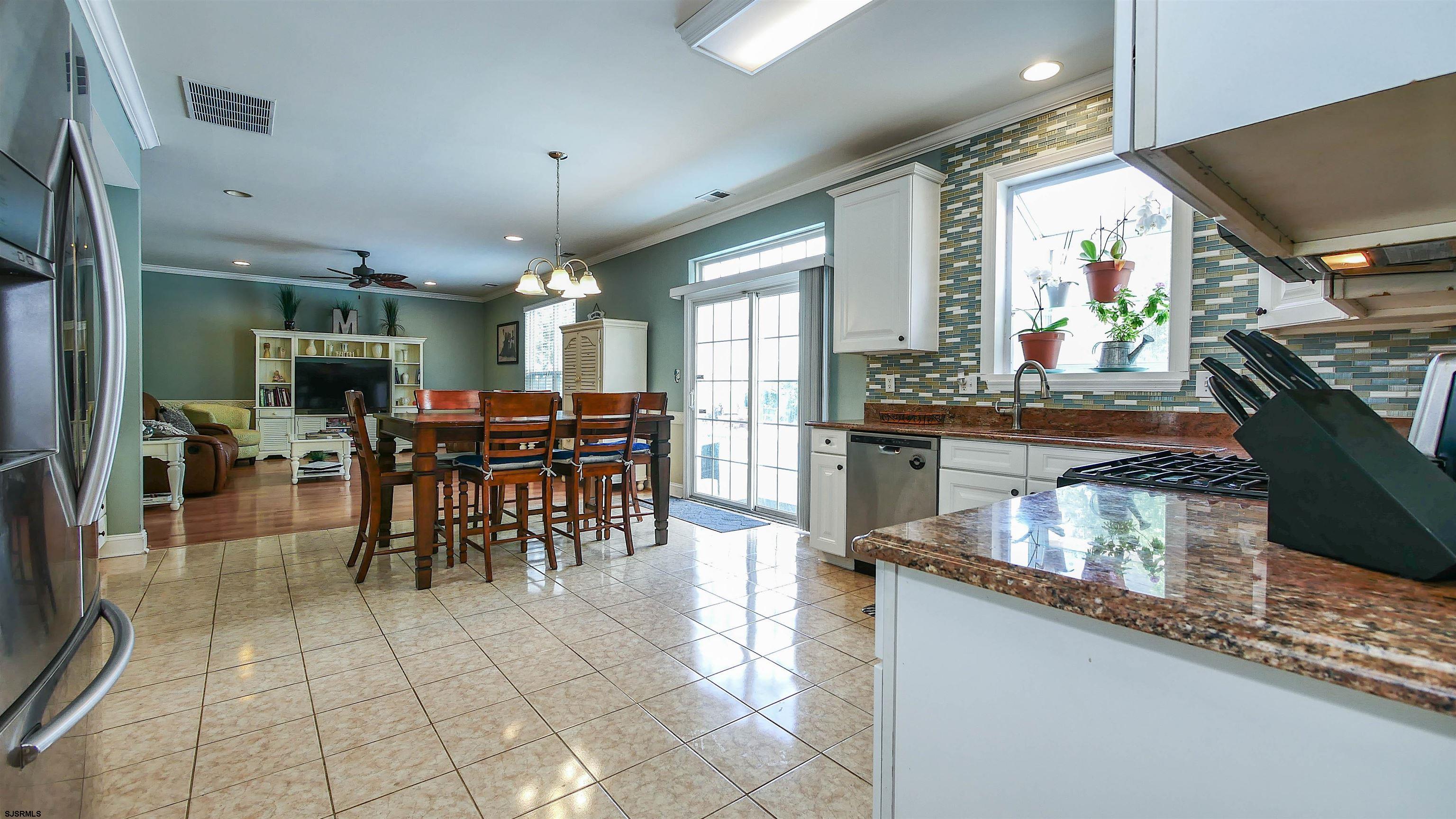 101 Haviv Drive Northfield, NJ 08225 - Photo 7 of 38 a kitchen with stainless steel appliances granite countertop a table chairs and a stove