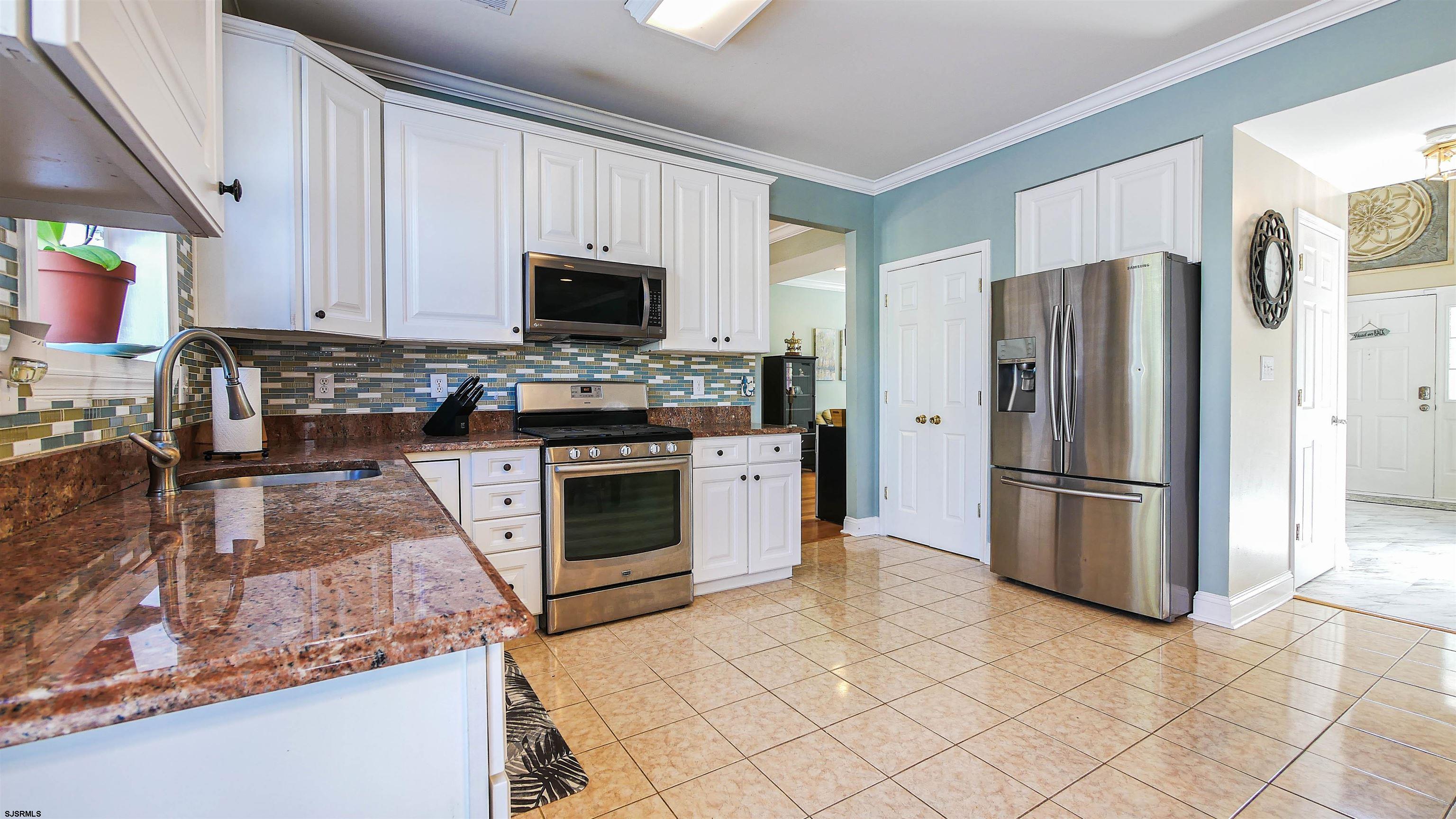 101 Haviv Drive Northfield, NJ 08225 - Photo 10 of 38 a kitchen with stainless steel appliances granite countertop a stove refrigerator and microwave