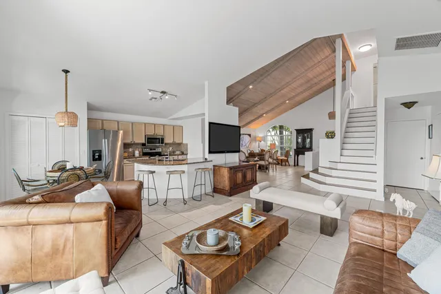 a living room with furniture and view of kitchen