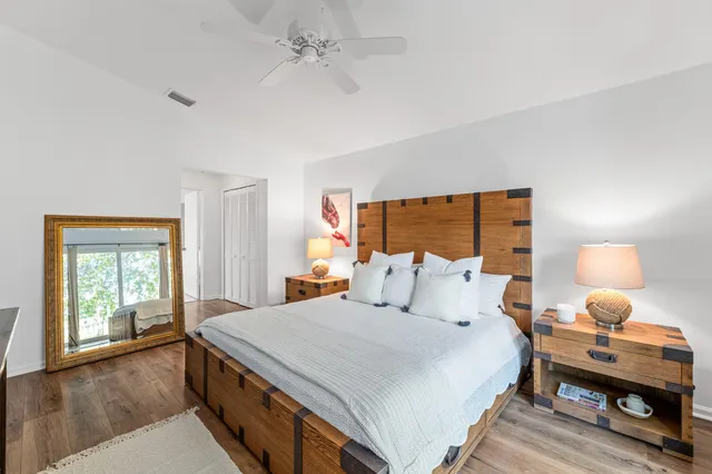 a bedroom with a bed a mirror and a window