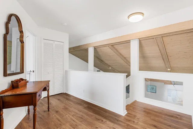 a view of a hallway with furniture and wooden floor