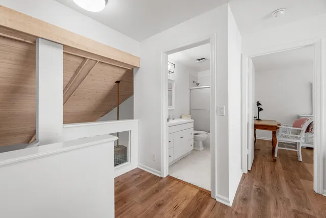 a view of a hallway view with wooden floor and living room