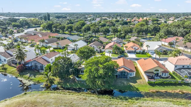 an aerial view of residential houses with outdoor space and trees