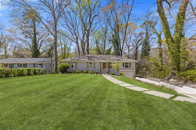 a front view of a house with yard and green space