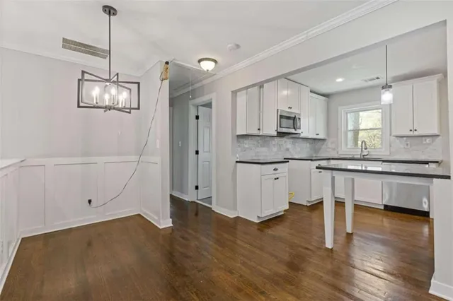 a kitchen with granite countertop white cabinets and white appliances