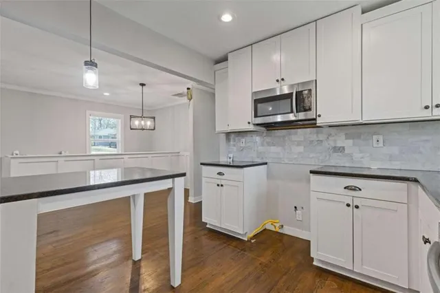 a kitchen with stainless steel appliances granite countertop a stove a sink and a microwave